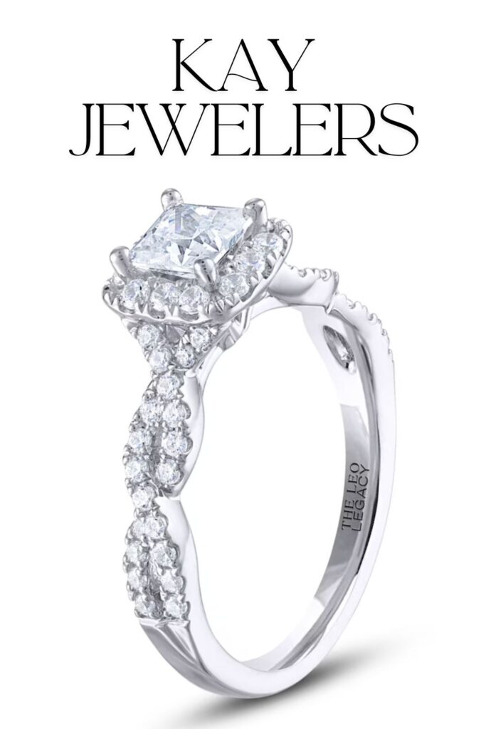 This 14K white gold engagement ring by Kay Jewelers features a stunning princess-cut lab-grown diamond in a halo setting, enhanced by smaller shimmering stones along the band. The intricate design showcases delicate pavé detailing, creating a modern and luxurious feel. The overall craftsmanship highlights both elegance and contemporary style, making it a remarkable choice for a timeless symbol of love.