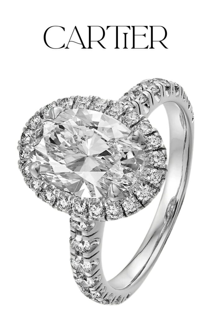 Cartier Destinée solitaire features an exquisite oval-cut diamond at its center, surrounded by a halo of brilliant-cut diamonds. The ring is elegantly set in platinum with a pavé band that enhances its luxurious appeal, embodying the craftsmanship and timeless design of Cartier.