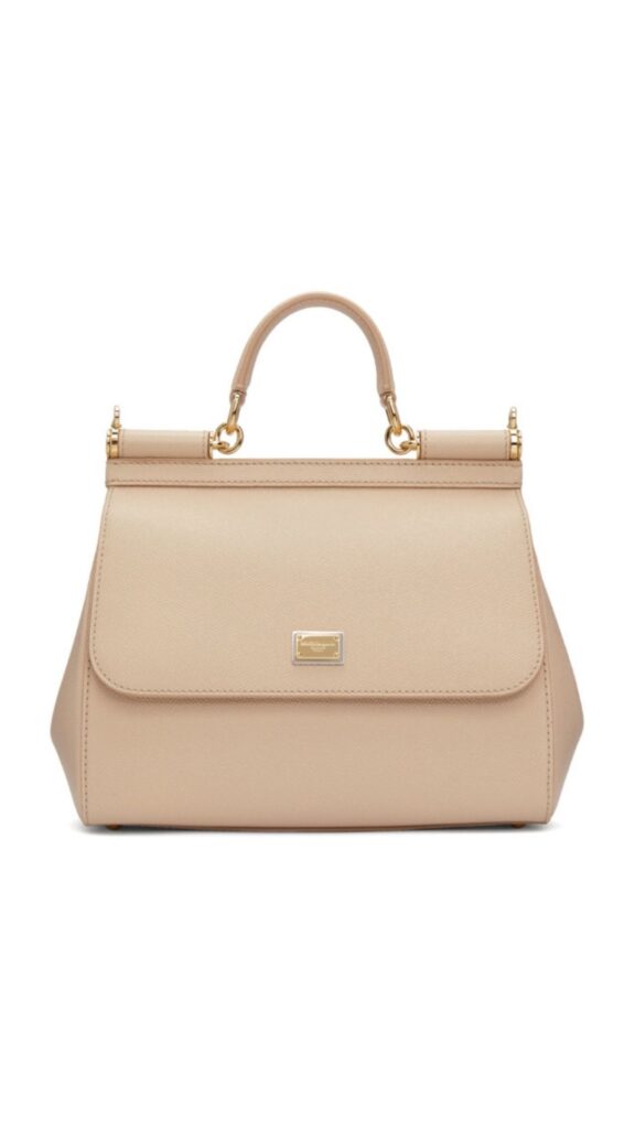 The Dolce & Gabbana Sicily Bag features a structured silhouette with a top handle and gold-tone hardware accents. It is crafted from smooth rose-hued leather, showcasing a sleek flap closure adorned with a designer plaque. This elegant handbag balances sophistication and functionality, making it a versatile accessory for various occasions.