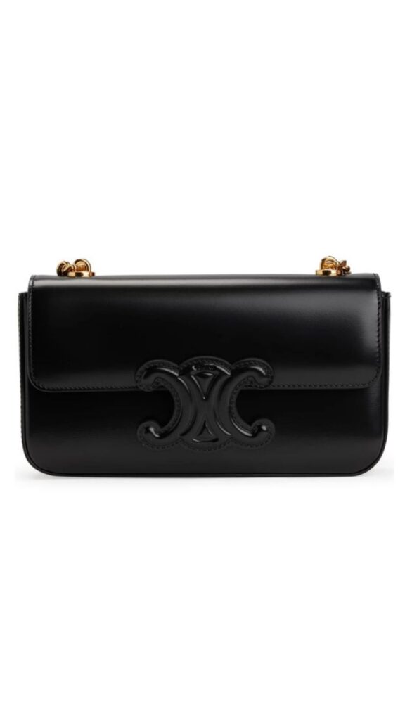 The Celine Cuir Triomphe is a sleek black leather handbag featuring a bold, embossed logo at the front. It has a structured silhouette with a flap closure and gold-toned hardware that adds a touch of elegance. This versatile piece is perfect for both day and evening wear.