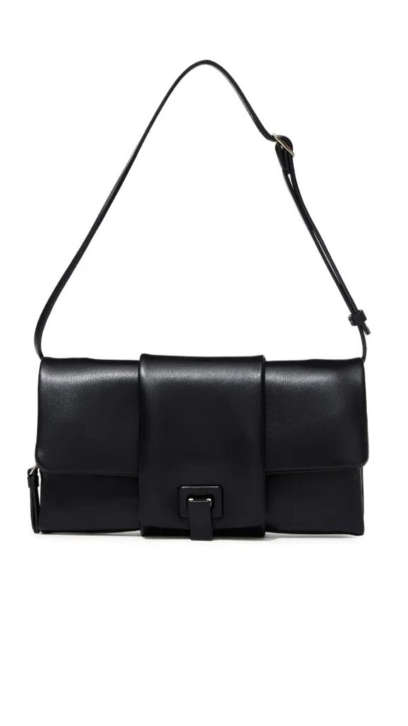 The Proenza Schouler Flip Shoulder Bag features a structured, rectangular silhouette with a sleek fold design and a clasp closure. It is crafted from smooth black leather, complemented by a slender shoulder strap for versatile carrying options. This minimalist accessory combines elegance and functionality, making it suitable for both casual and formal occasions.
